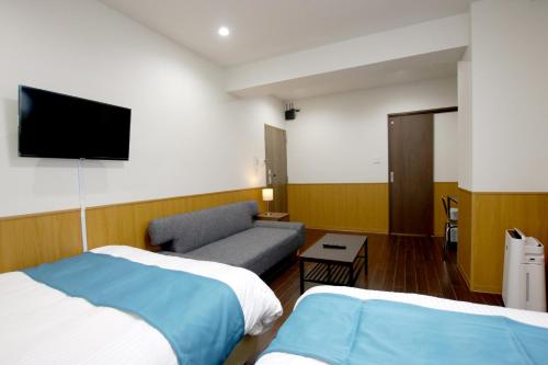 北谷町Phoenix Ryukyu Henzanbaru -SEVEN Hotels and Resorts-的酒店客房,设有两张床和一张沙发