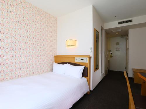 苫小牧市苫小牧永安国际酒店的配有一张床和一张书桌的酒店客房