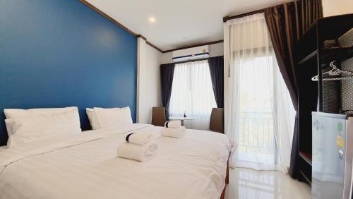 乌泰他尼府Sabua The Terrace Homestay的卧室配有一张白色大床和两条毛巾