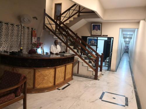 斯里卡拉哈斯蒂Sridhar Lodge的站在酒吧的有楼梯的房间的人