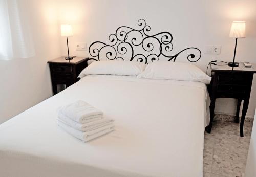 巴尔巴特Hostal Trafalgar的卧室配有白色床和毛巾
