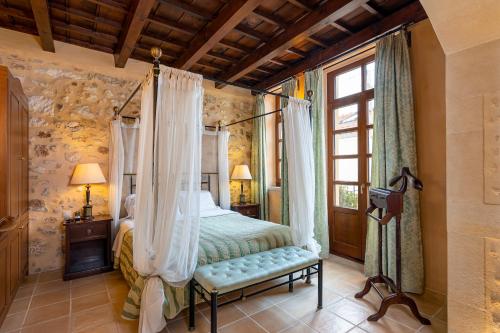 罗希姆诺帕拉齐诺帝科里纳酒店的一间卧室设有天蓬床和窗户。