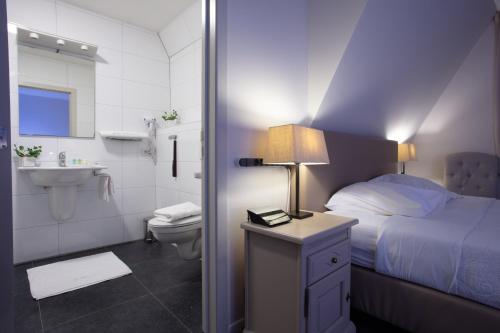 Asse拉查米耶尔酒店的一间卧室配有一张床,浴室设有水槽