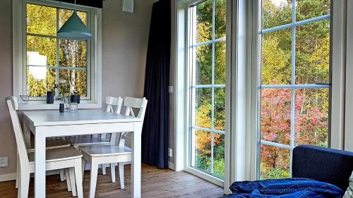 莫拉Nybyggd stuga intill skogsbrynet - New built cottage next to the cowberry forest的窗户客房内的白色桌椅