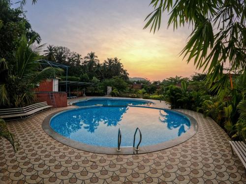戈卡尔纳Arthigamya Spa & Resort的一座享有日落美景的游泳池