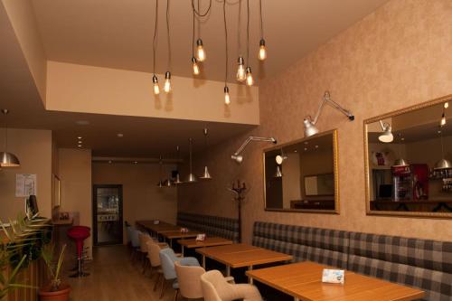 旧扎戈拉Hotel Motto的餐厅设有木桌、椅子和镜子