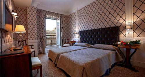 罗马特雷维精品酒店的一间卧室设有一张大床和一个窗户。