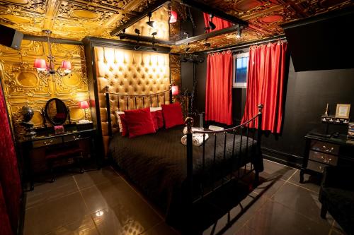 布莱顿霍夫Brighton Erotic Boudoir的一间卧室配有一张带红色枕头的大床