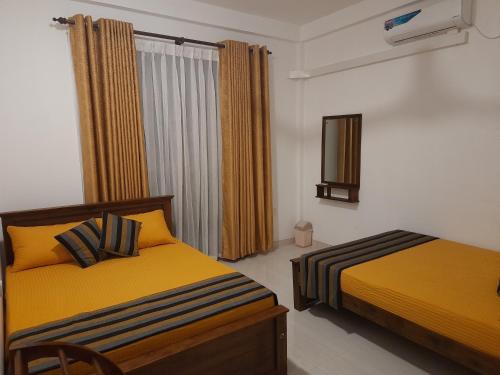 阿努拉德普勒Elite Holiday Home, Anuradhapura的一间卧室设有两张床和窗户。