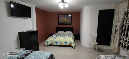 曼塔Casa Paraíso的一间卧室配有一张床和一台电视