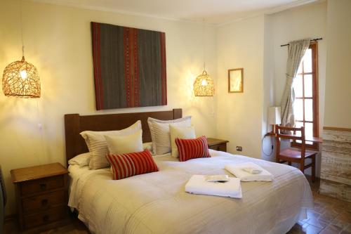 普特雷露台小屋旅馆的卧室配有带红色枕头的大型白色床