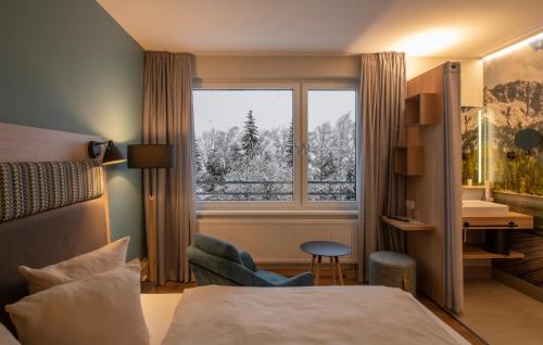 施伦斯TUI BLUE Montafon的酒店客房设有床和窗户。