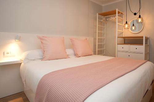阿维拉La Casa de Mozo的卧室配有一张带粉红色枕头的大床