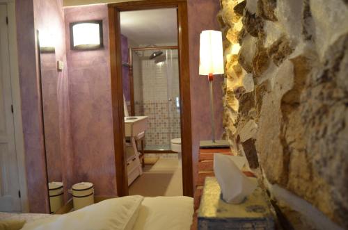 洛索亚河畔布伊特拉戈拉比尔纳夏酒店的一间卧室,带石墙的浴室