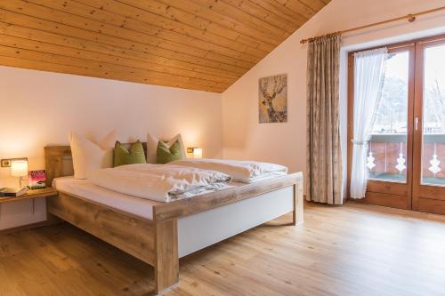 鲁波尔丁Ferienwohnungen Beim Zellerbäck的一间卧室设有一张带木制天花板的大床