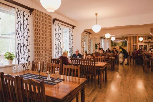 StorseleJärjagården Hostel的餐厅设有木桌,客人坐在桌子旁
