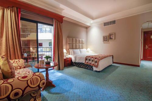 麦纳麦Panorama Hotel and Spa的卧室配有床、椅子和窗户。