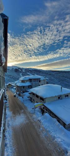 阿贝托内Mansarda Abetone的一条有建筑物和道路的雪覆盖的街道