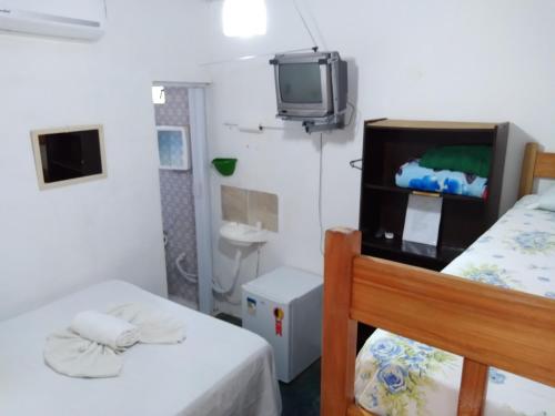 伦索伊斯Chapada Casas da Izete的客房设有两张床和一台墙上的电视