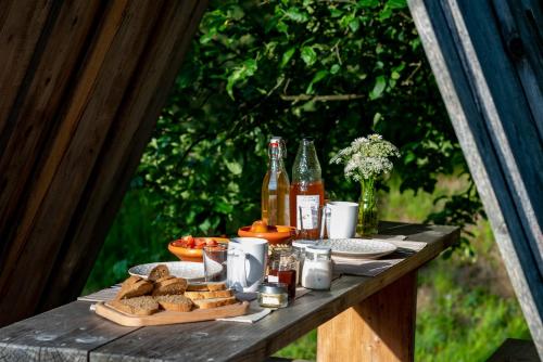 扎雷克Glamping - Ekološka kmetija Kozman的一张野餐桌,包括面包和瓶装啤酒及饮料