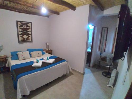 普尔马马尔卡Los Agustinos的一间卧室配有蓝色和白色床单