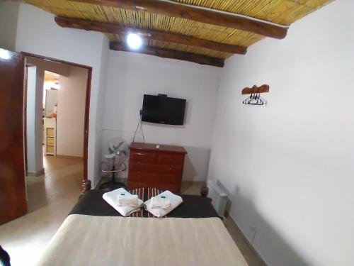 普尔马马尔卡Los Agustinos的卧室配有一张床,墙上配有电视。