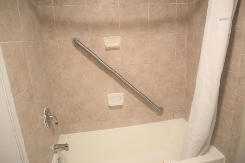 诺克罗斯Baymont by Wyndham Norcross Atlanta的设有带白色浴缸的淋浴的浴室