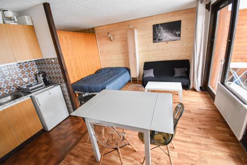 圣让多尔普Le Relai S34 - Grand et lumineux studio avec coin montagne 4-6 pers avec WIFI, 50m des pistes, grand balcon exposé SUD, DRAPS NON COMPRIS的客厅配有桌子和沙发