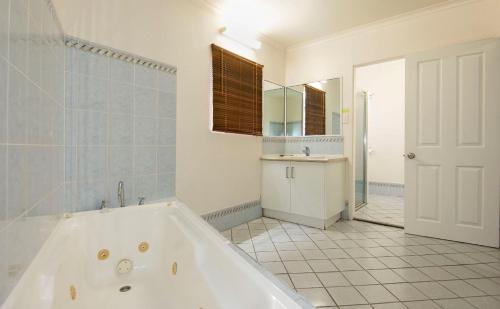 麦凯克拉尔桑德汽车旅馆的带浴缸、水槽和镜子的浴室
