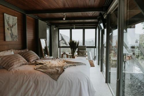伦邦villa tibra的一间卧室设有一张大床和一个大窗户