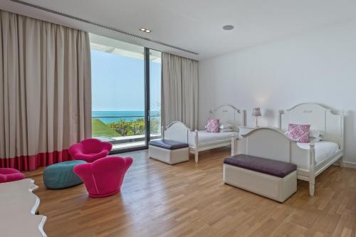 阿布扎比Paradise Nurai Villa - 6 Bedrooms的卧室配有白色家具和大窗户