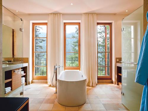 厄茂Schloss Elmau Luxury Spa Retreat & Cultural Hideaway的带窗户的客房内设有带大浴缸的浴室