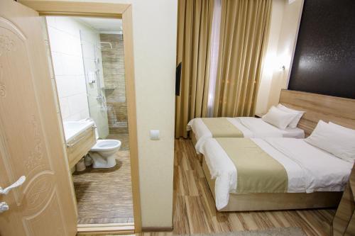 奥什Level的一间带两张床的卧室和一间带卫生间的浴室