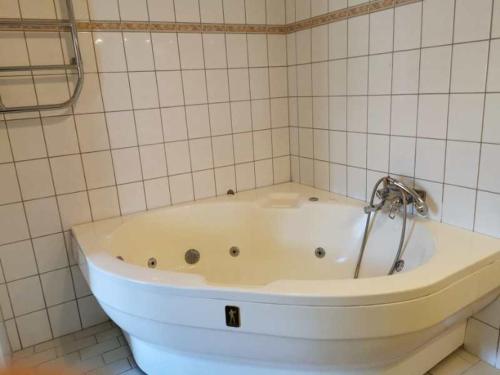 博伦厄Ulfshyttans Herrgård, nära Romme Alpin的瓷砖浴室设有白色浴缸。
