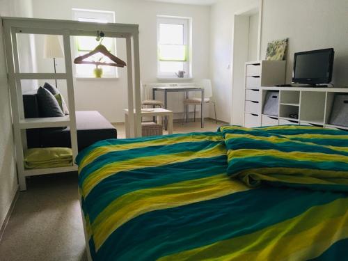 伦斯泰格地区施米德费尔德Pension SPORT-SCHMIEDE的一间卧室配有一张带彩色毯子的床