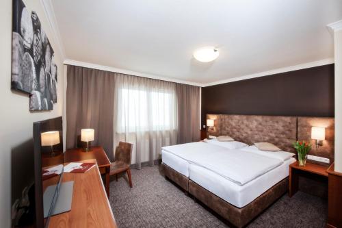 Hotel Weinberg GmbH的配有一张床和一张书桌的酒店客房