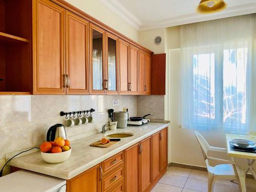 锡德梅利莎花园公寓酒店的厨房配有木制橱柜和柜台上的一碗橙子