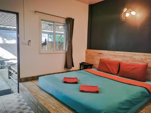 奥南海滩格拉旅馆的一间卧室配有一张大床和红色枕头
