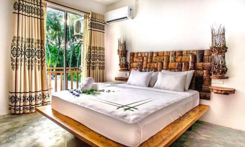 弗里德胡岛屿度假宾馆的一间卧室设有一张大床和一个大窗户