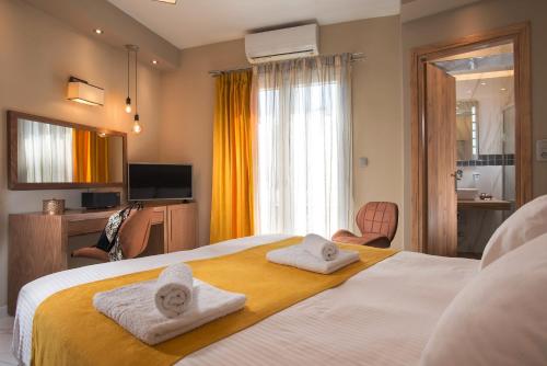 阿达玛斯Angelica's Deluxe Rooms in Adamas的酒店客房的床上配有2条毛巾