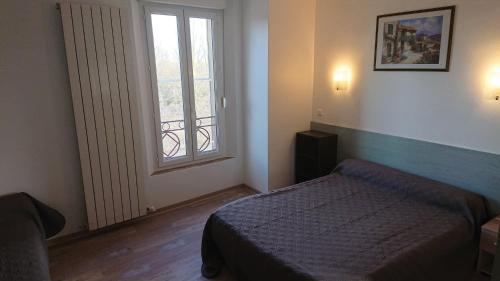拉卡瓦勒里Auberge le Cévenol的一间小卧室,配有床和窗户
