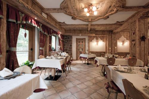 莫埃纳Resort Dolce Casa - Family & Spa Hotel的餐厅配有带白色桌布的桌子