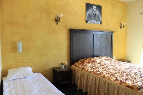 桑丹斯基克洛希奥精品酒店的卧室配有一张床,还展示了一张男人的照片