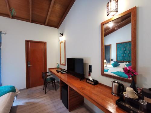 福拉杜岛Village Hideaways & Spas的一间卧室配有一张带镜子的桌子和一张床