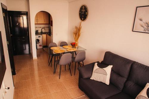 托雷维耶哈Aparthotel Costa Blanca的客厅配有沙发和桌椅