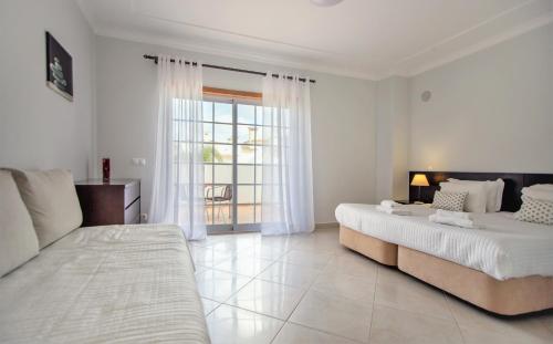 阿尔布费拉阿尔布费拉别墅酒店的一间白色卧室,配有两张床和窗户