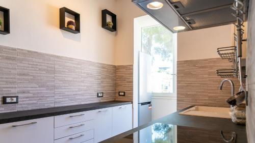 费拉约港Appartamento di Daniele的厨房配有白色橱柜和水槽