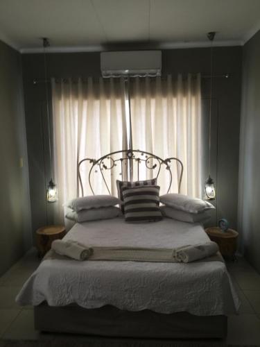 温特和克Spinoza Self Catering Accommodation的卧室配有带枕头的床铺和窗户。