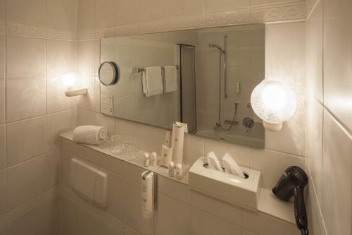 维林根伯格霍夫酒店的白色的浴室设有水槽和镜子