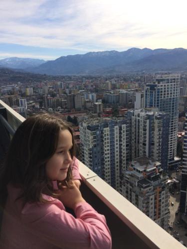 巴统Orbi Сity Sunny Apartments high floor的坐在建筑物的顶端的年轻女孩